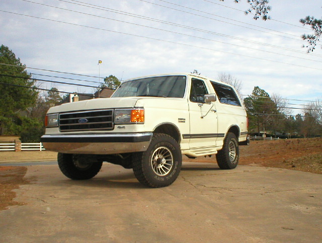 White full-size Ford Bronco 4x4 on alloy wheels and all-terrain tires, front three-quarter view