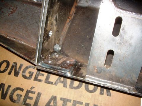 1995 Ford Bronco - Close-up of the inside corner of a fabricated bare-steel bumper, showing welded seams, a captive nut behind the mounting face and a slotted…