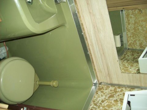1985 Ford Bronco - Interior view of a compact RV bathroom a toilet and sink area.