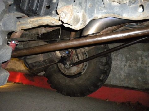 1989 Ford Bronco - Undercarriage view shows suspension and exhaust system of a vehicle with large tires.