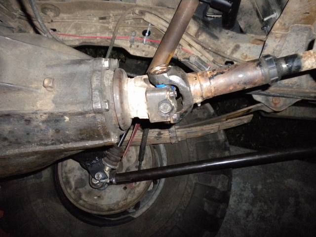 Underside close-up of transmission output, U-joint and rear driveshaft