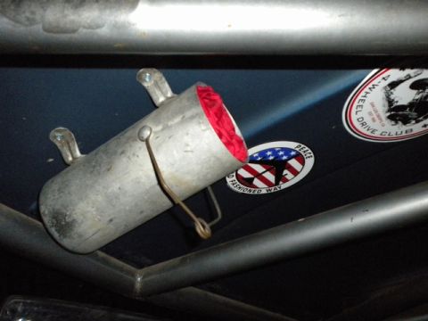 1989 Ford Bronco - Interior view of a vehicle's roll cage with a metal canister and stickers on the blue paneling.