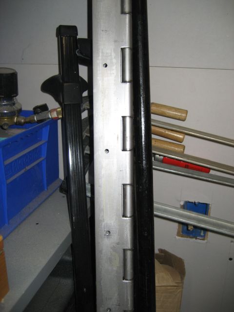 1996 Ford Bronco - Metal hinges and tools are visible in this close-up shot, with a blue bin in the background.