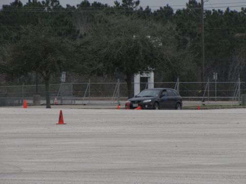 2003 Mazda Protege - A dark 2003 Mazda Protege hatchback is parked on a lot, with orange cones marking a course.