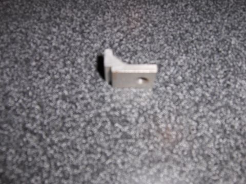 1977 Pontiac Trans Am - A small metal bracket is shown against a textured gray background.