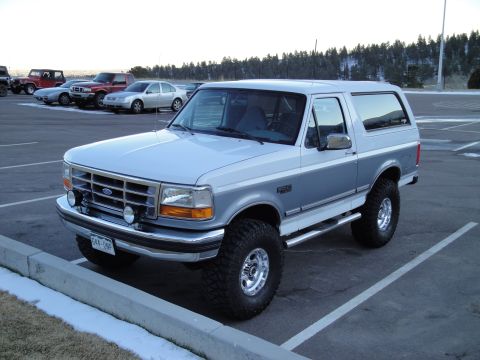 1995 Ford Bronco - This 1995 Ford Bronco is parked in a lot with other vehicles visible in the background.