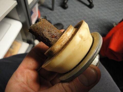 1995 Ford Bronco - A close-up of a corroded metal component, likely a vehicle part, held in a person's hand.