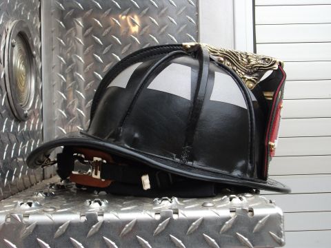 1992 Ford F-150 - A firefighter's helmet rests on a textured metal surface, with a portion of a vehicle visible in the background.