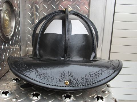 1992 Ford F-150 - A black leather firefighter helmet with reflective stripes and embossed leaf pattern is shown up close.
