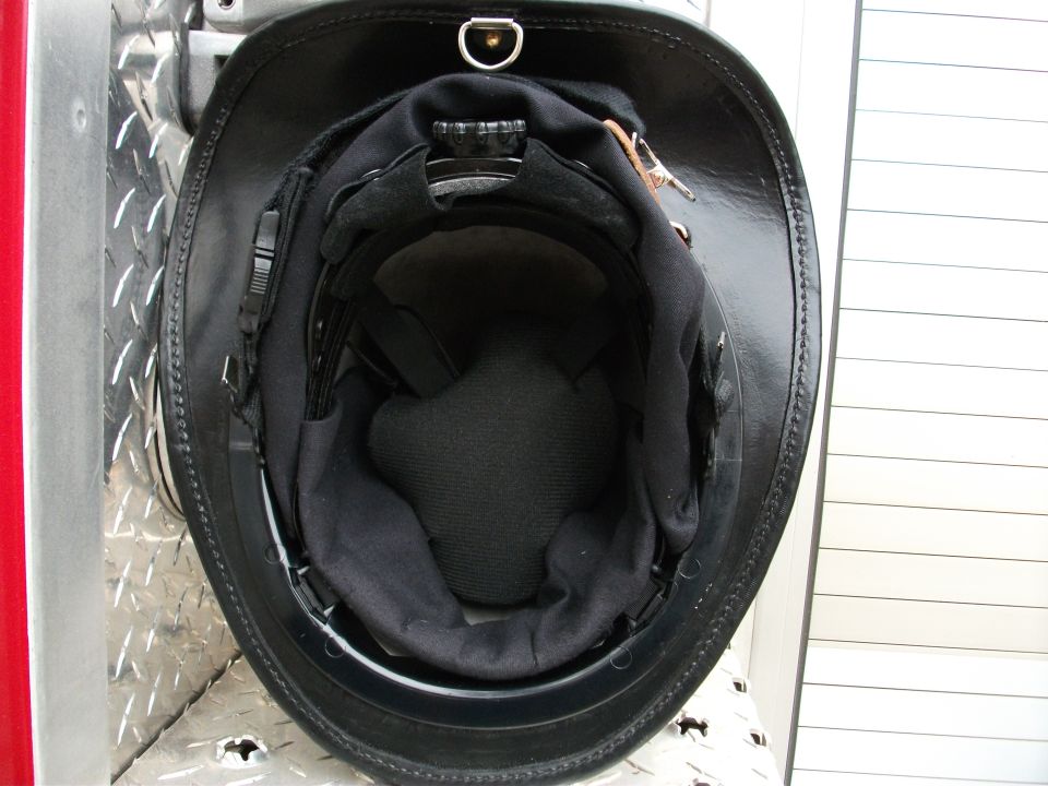 Black leather helmet with padded interior on diamond-plate surface