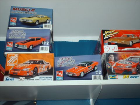 1978 Ford Mustang II - A collection of model car kits are displayed on a shelf, various classic and racing vehicles.