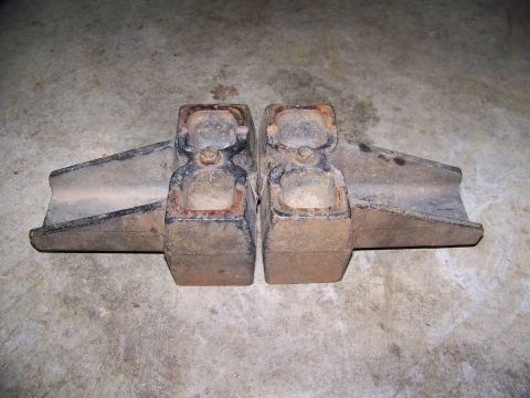 2001 Dodge 1500 - Two rusty metal brackets are shown from a top-down perspective on a concrete floor.