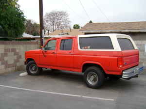 1986 Ford Bronco - This extended cab pickup truck with a camper shell appears to be from the early 1980s, likely a Ford F-Series.