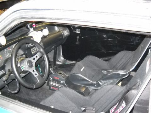1992 Ford Mustang - The interior of a modified vehicle features racing seats, a custom steering wheel, and a dashboard with auxiliary gauges.