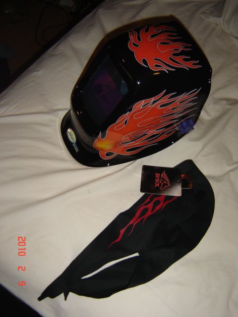 1993 Ford Bronco - A black welding helmet and gloves with flame graphics are displayed on a white surface.