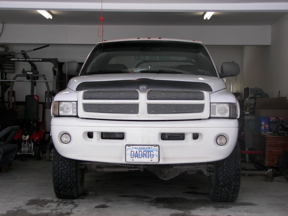 Front view of a white Dodge Ram pickup truck with an Alaska license plate that reads DADRIG