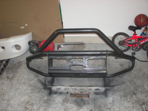 1990 Chevrolet Suburban - A heavy-duty brush guard is shown on a garage floor, with a bicycle and basketball visible in the background.