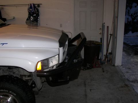 1990 Chevrolet Suburban - Front view of a white truck equipped with a black bull bar, parked inside a garage.