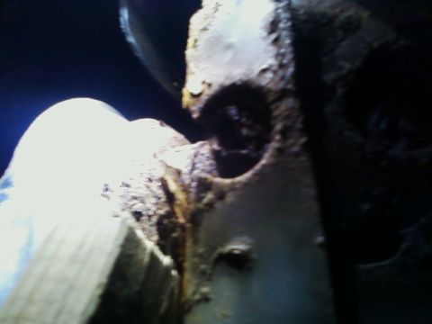 1990 Ford Bronco - Close-up of a corroded metal component, likely from a vehicle's undercarriage.