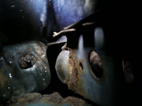 1990 Ford Bronco - This image shows heavily corroded metal components, likely part of a vehicle's structural framework.