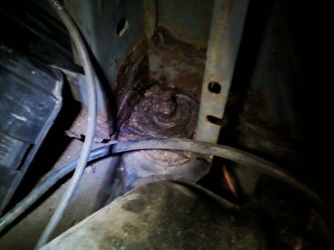 1990 Ford Bronco - Close-up of heavily rusted metal frame and hoses, showing significant corrosion.