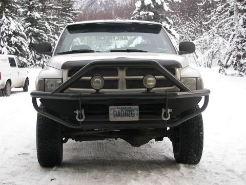 1990 Chevrolet Suburban - A white pickup truck is parked in a snowy landscape, a prominent black bull bar and an Alaska license plate.