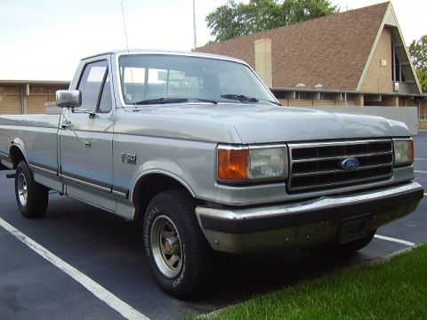 1996 Ford F-150 - This silver Ford F-150 pickup truck is seen from a 3/4 front angle in a parking lot.