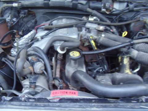 1996 Ford F-150 - Close-up view of a vehicle's engine bay, showing various mechanical parts and hoses.