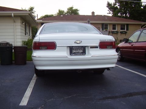 1996 Ford F-150 - Rear view of a white 1994 Chevrolet Caprice Classic sedan parked next to a red car.