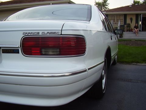 1996 Ford F-150 - A white sedan is parked in a driveway with a house and lawn in the background.