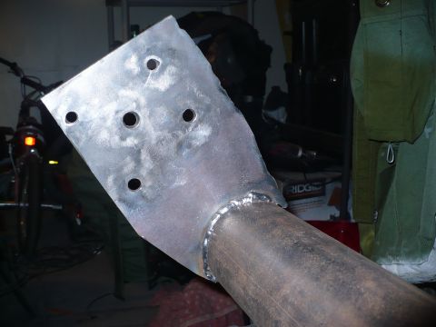 1979 Ford Bronco - Close-up of a custom metal bracket welded to a pipe, with visible holes for mounting.