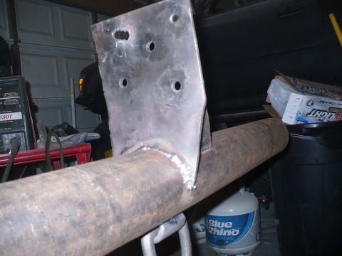 1979 Ford Bronco - Custom trailer hitch bracket welded to exhaust pipe, with welding equipment in the background.