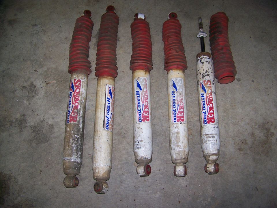 Five Skyjacker Hydro 7000 shocks with red boots, one boot separate