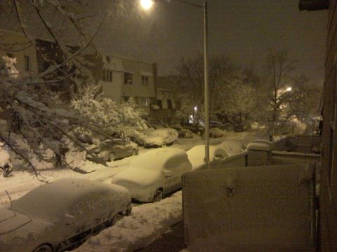 2007 Subaru Impreza - A street scene at night during a snowstorm, with multiple vehicles covered in snow.