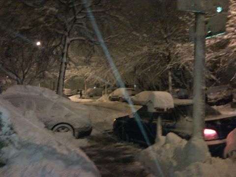 2007 Subaru Impreza - Cars are parked on a snow-covered street at night during a heavy snowfall.
