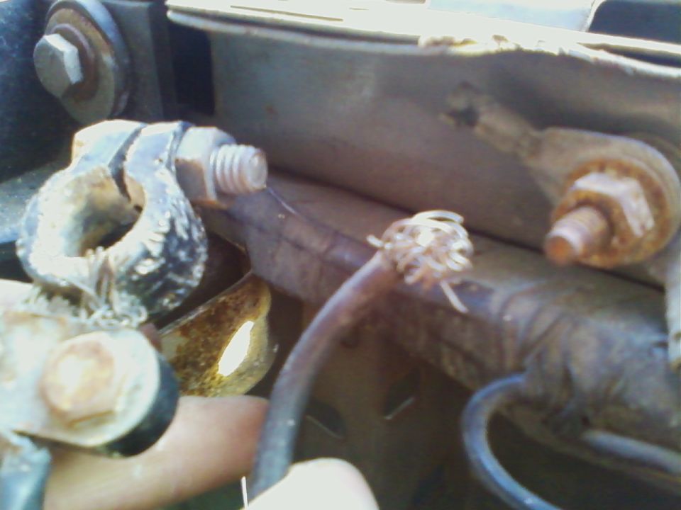 Corroded battery terminal with a frayed wire connected to it