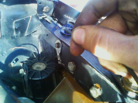 1990 Ford Bronco - A person is working on automotive wiring, connecting a terminal to a bracket in what appears to be an engine bay.
