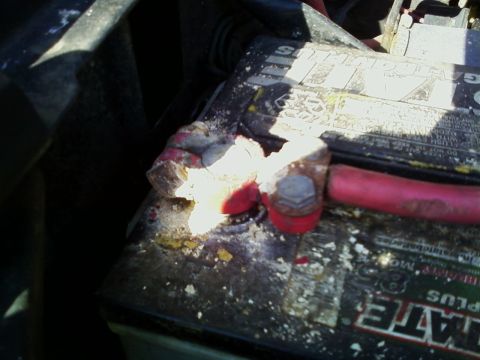 1990 Ford Bronco - Close-up of a heavily corroded battery terminal, showing significant white and yellow buildup around the connection.