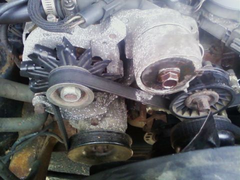 1990 Ford Bronco - Close-up of engine belts and pulleys, showing signs of wear and corrosion.