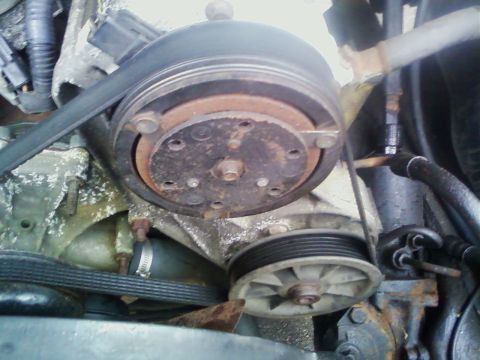 1990 Ford Bronco - This image shows a close-up view of the engine's belt and pulley system, with visible signs of wear and rust.