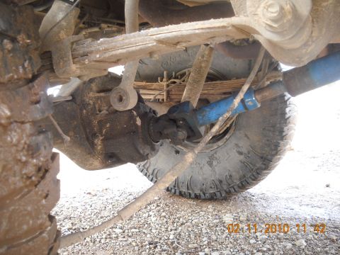 1979 Ford Bronco - Close-up view of the undercarriage, showing the suspension system and driveshaft of a vehicle.