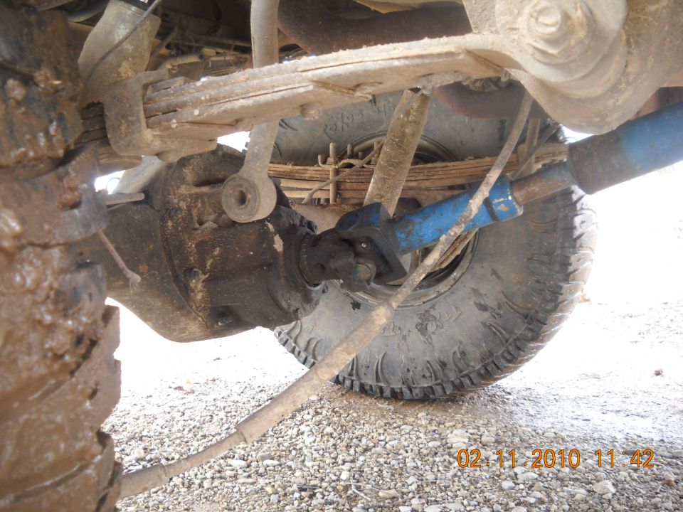 Undercarriage view of vehicle suspension with leaf springs and driveshaft