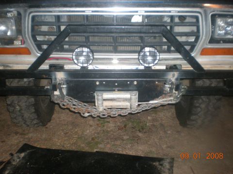 1979 Ford Bronco - The front of a Ford truck is shown, a winch and a custom brush guard. The grille suggests a 1980s model year.