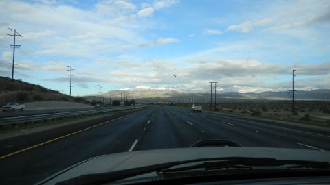 1997 Ford Ranger - A highway stretches towards distant mountains, with power lines and wind turbines dotting the landscape.