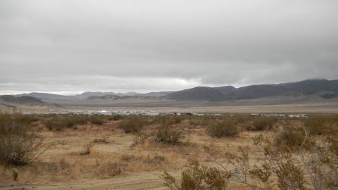 1997 Ford Ranger - Distant vehicles are visible in a desert valley with mountains in the background.