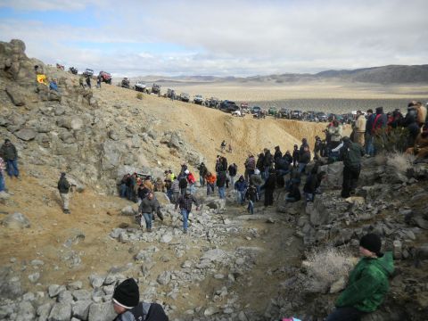 1997 Ford Ranger - A large group of spectators watches off-road vehicles navigate a challenging desert terrain.
