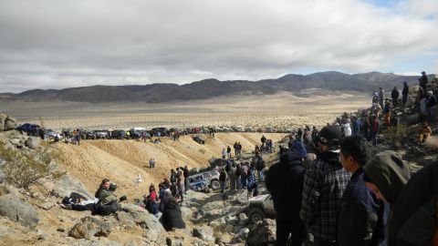 1997 Ford Ranger - A large crowd watches off-road vehicles navigate a challenging desert course, with numerous vehicles parked in the background.