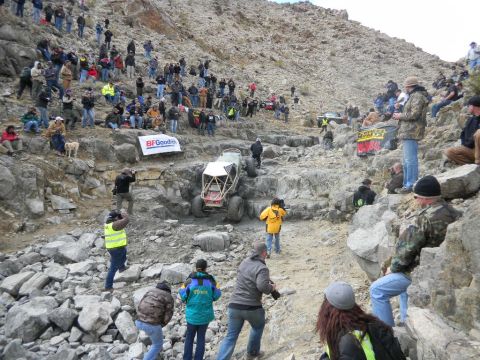 1997 Ford Ranger - A custom off-road buggy navigates a steep, rocky terrain with a crowd of onlookers observing the event.