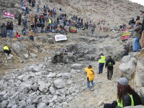 1997 Ford Ranger - An off-road buggy navigates a challenging rocky terrain during an event, with spectators lining the hillsides.