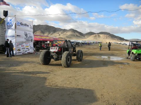 1997 Ford Ranger - An off-road buggy is seen at a desert event with multiple tents and vehicles in the background.